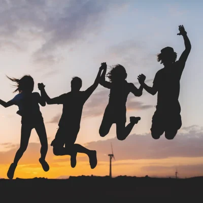 Glückliche Jugendliche springen in die Luft nach erfolgreicher Teilnahme an einem Workshop von Psychologe König.